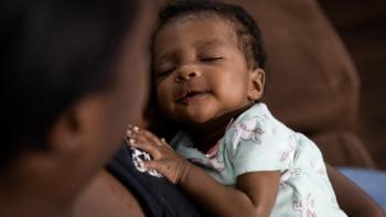 Baby being held by mother.