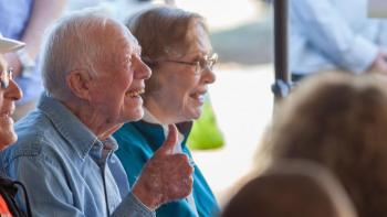 Jimmy Carter giving thumbs up next to Rosalynn Carter smiling.