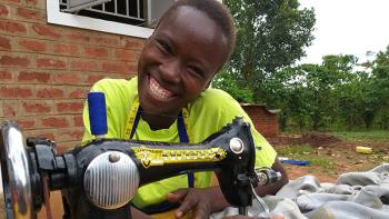 Photo: Evelyn with her Singer sewing machine which was included in her startup toolkit