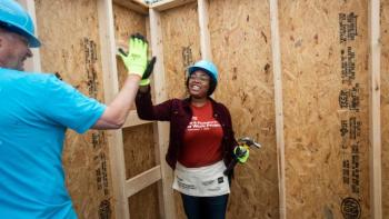 Homeowner high-fives a volunteer.