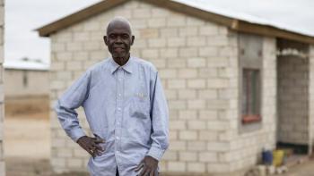  Zambian homeowner Jonathan in front of his home.