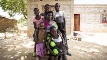 The Musonda family in front of their new home in Zambia built with the support of Habitat International and achieved through the Solid Ground Campaign.