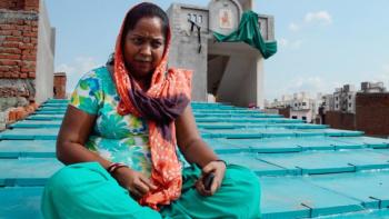 Woman in India sitting on her new roof by ReMaterials.