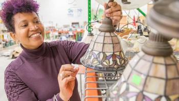 Woman with purple hair picking out a lighting fixture in a Habitat ReStore