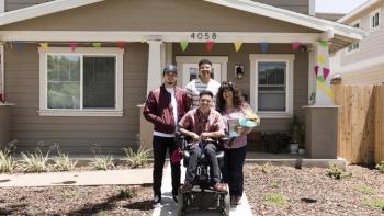 Mulvihill family smiles in front of their new accessible Habitat home. 