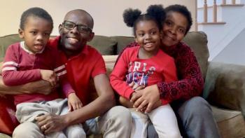 Ingrid and her family smiling on their couch.