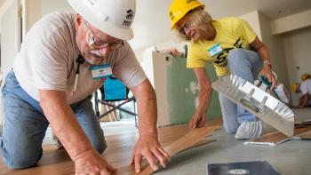 RV Care-A-Vanner volunteers lay down flooring.