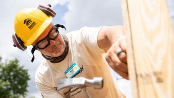 A volunteer hammers on a build site.