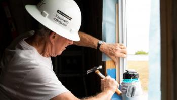 A volunteer hammering on a build site.