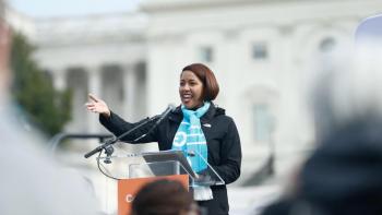 Woman in blue Habitat scarf speaking at podium in Washington, D.C.