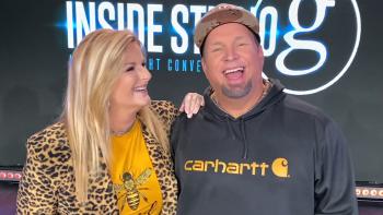 Trisha Yearwood and Garth Brooks smiling on set.