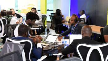 A group of people in a room working on laptops.