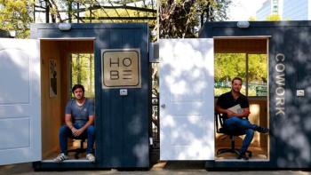 Photo of two men from startup HOBE sitting inside small structures.