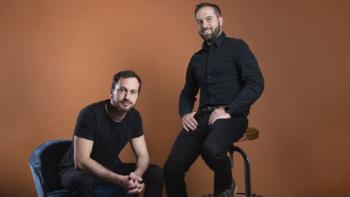 Two men posing for a promotional photo.