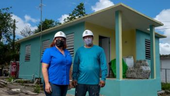 Elizabeth and Javier standing outside a blue home.
