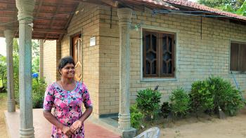 Thushanthini outside her home built with compressed stabilized earth blocks in Sri Lanka