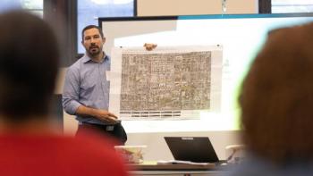 A man presents blueprints.