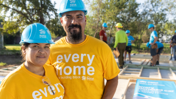 Habitat homeowners in hardhats on build site