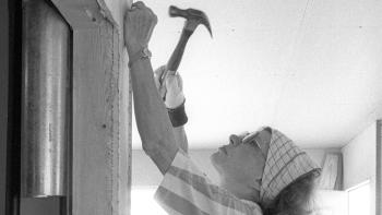 Black and white photo of Rosalynn Carter hammering nails into a wall