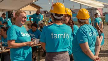 Volunteers gathered around talking on the site of a Hope Build