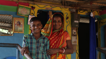 Mother and son smiling in a colorfully painted house. 