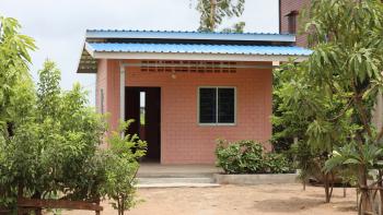 Pink brick house with blue roof.