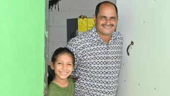 Un hombre y su hija en la puerta de una casa