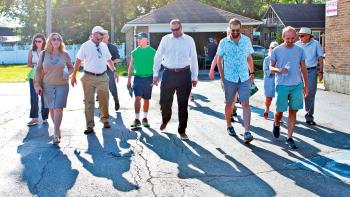 A group of homeowners and volunteers standing on a street together.