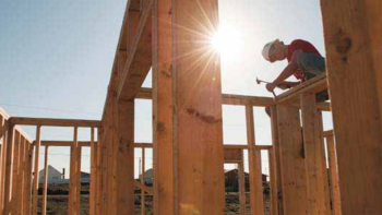 Volunteer hammering framing on house