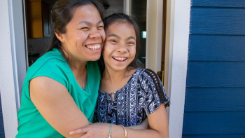 Mom and daughter hugging in doorway of new home