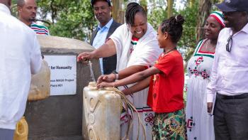A group of people fetch water at a water point