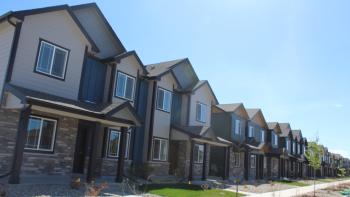 A row of two story houses and a sidewalk.