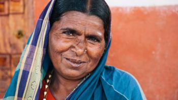 Woman in colorful head covering looking at camera with slight smile