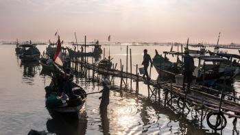 Fishermen heading out to their boats in the early morning light.