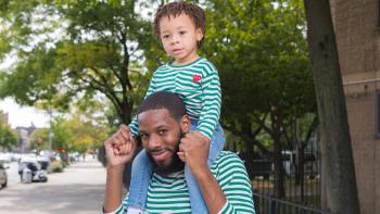 Jason carrying his young son on his shoulders.