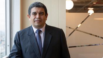 A man in a suit looks straight ahead