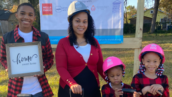 Sara with her three children in hard hats.