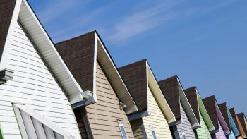 Different colored rooftops at an angle against a clear blue sky.