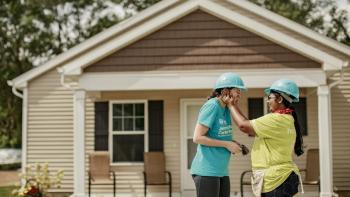 Homeowner Nusrat Zahan hugs Notre Dame student Emma Erwin in front of Zahan's home 2018 Habitat for Humanity Jimmy and Rosalynn Carter Work Project in St. Joseph County, Indiana, 
