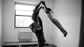 Black and white photo of a mother swinging her daughter around.