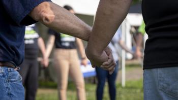 A group of volunteers clasp hands together to pray before a build project. 