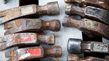 Hammer heads facing toward each other.  Hanging on a board.