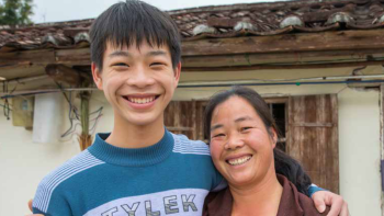 Mother and her taller adolescent son smiling together