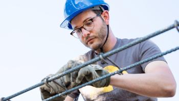 Man in hardhat on build site.
