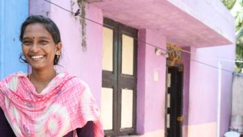 Smiling woman standing in front of colorful building