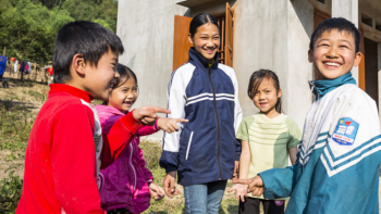 Five Vietnamese children playing together and laughing