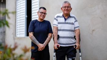 Kinha and his father outside their new home.