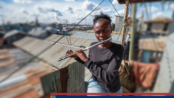 A woman on a patio plays a flute.