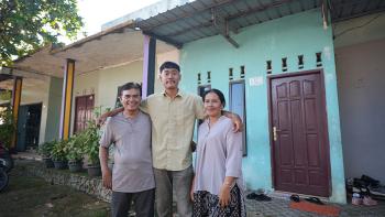Hendra, son Santo and wife Erta outside their home in Batam, Indonesia