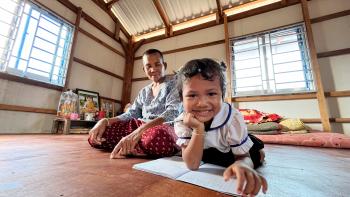 Parent and child smiling at the camera in a large room.
